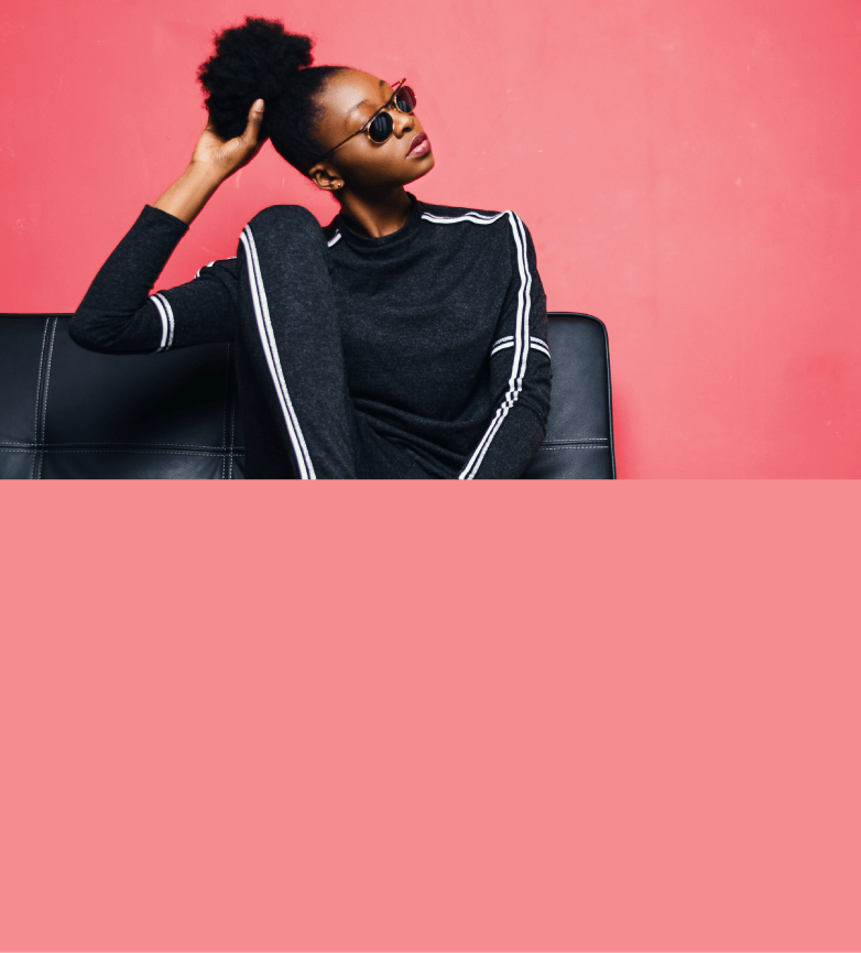 Modelo preto de bigode, óculos de lentes transparentes e terno branco estiloso em fundo laranja