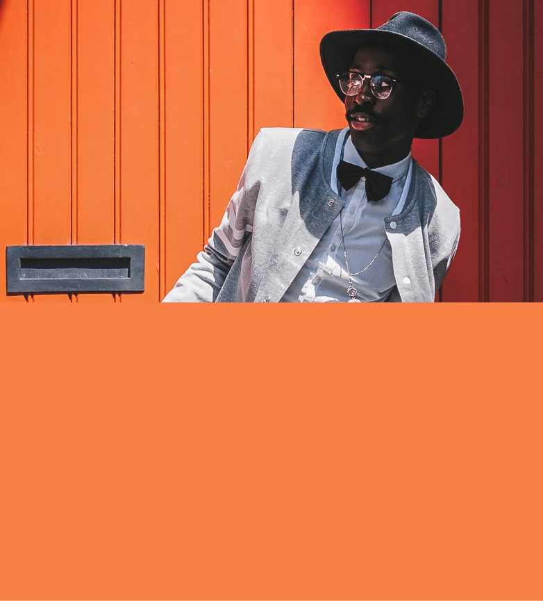 Modelo de óculos escuros, coque alto e apertado em roupa preta estilosa em fundo salmão.